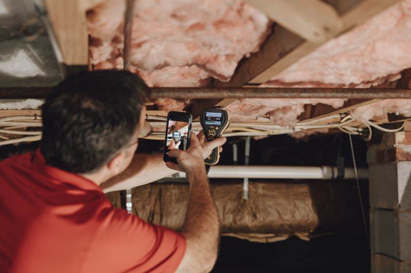 Technician checking crawl space moisture levels